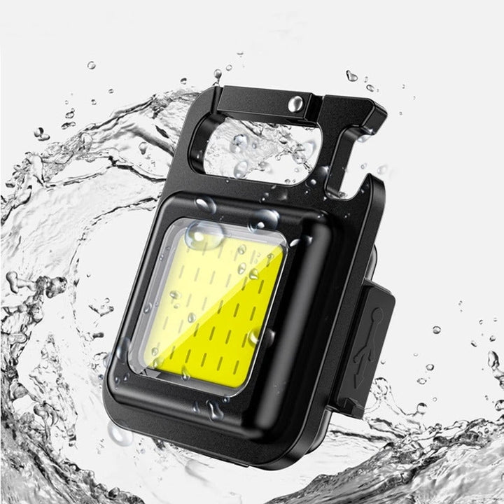 Mini rechargeable LED flashlight keychain with COB light, multi-tool features. Ultra-portable for everyday carry.