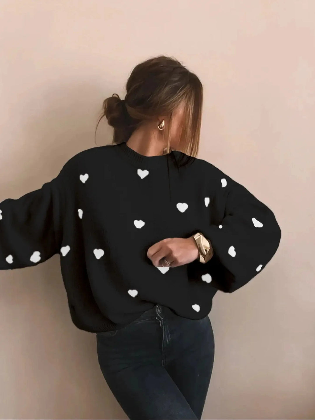 Woman modeling an oversized heart embroidered jumper, demonstrating its cozy and casual style.