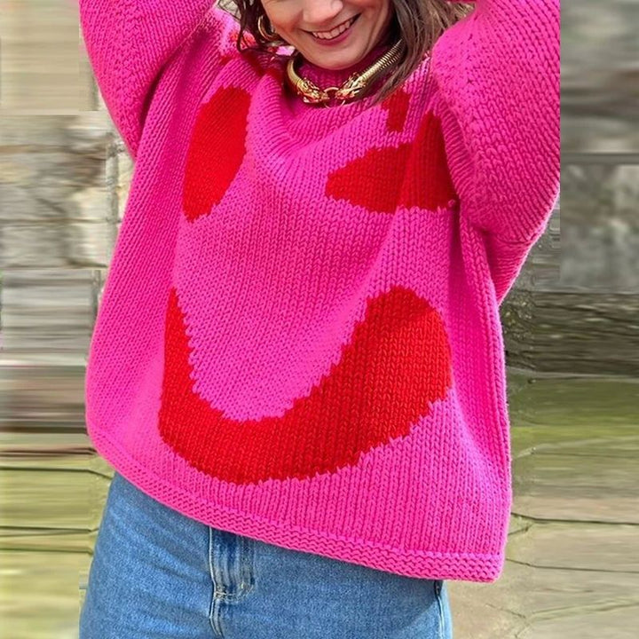 Women's casual oversized knit sweater, featuring a fun smiley face graphic, ideal for relaxed winter fashion.