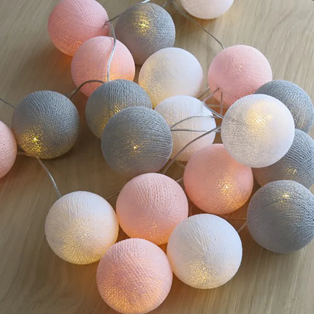 Decorative warm LED cotton ball string lights adding a subtle, elegant touch to a bedroom.