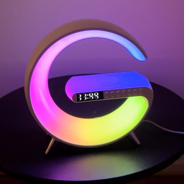 Universal wireless charger with integrated clock, Bluetooth speaker, and vibrant RGB ambient light. A modern desktop organizer.