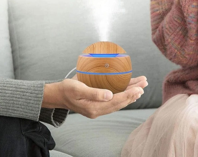 Wood grain essential oil diffuser creating a tranquil, spa-like ambiance in a cozy room.