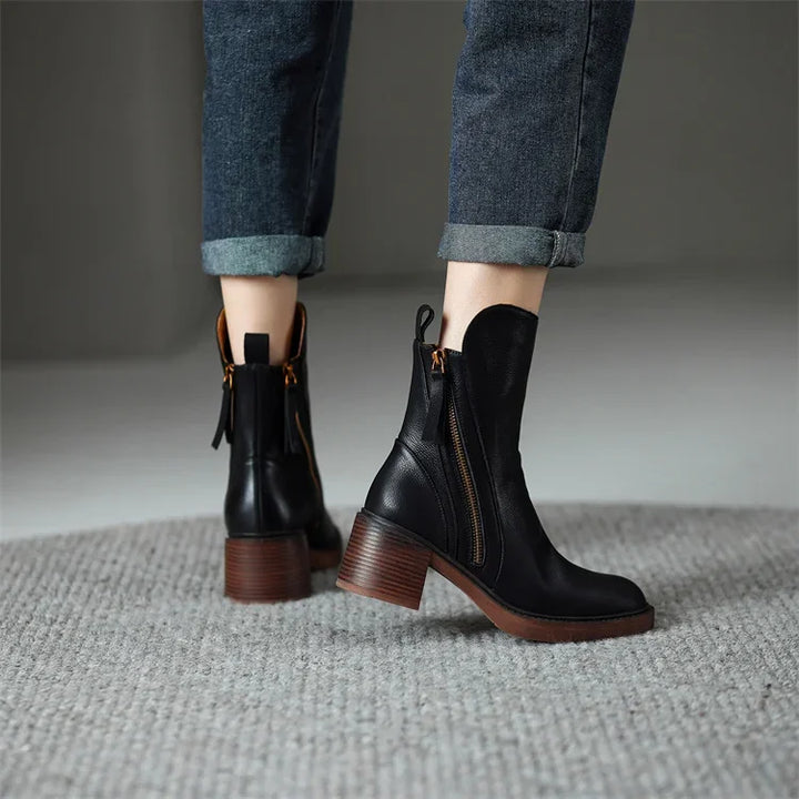 Close-up of elegant women's black zip ankle boots, highlighting the stylish zipper and premium material.