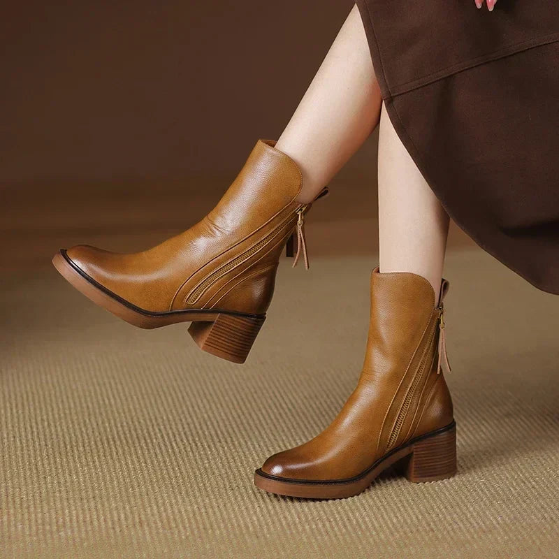 Stylish women's brown zip ankle boots with a comfortable platform heel, embodying classic style & elegance.