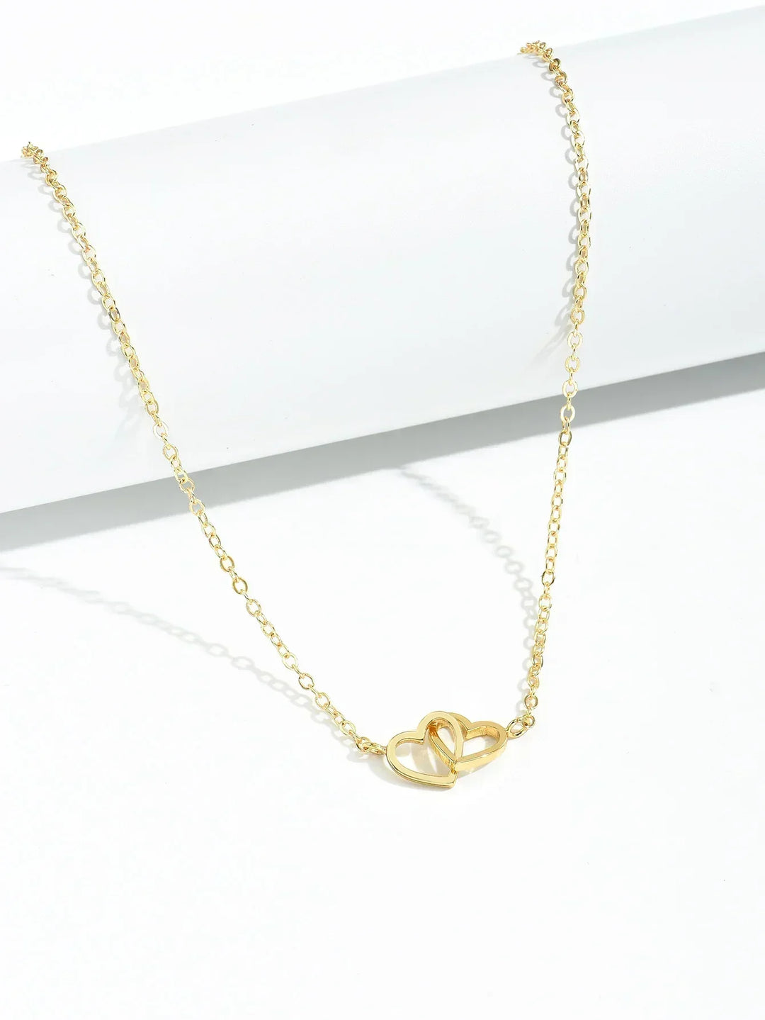 Elegant women's gold vermeil interlocking heart necklace worn, showcasing delicate sterling silver heart pendant jewelry.