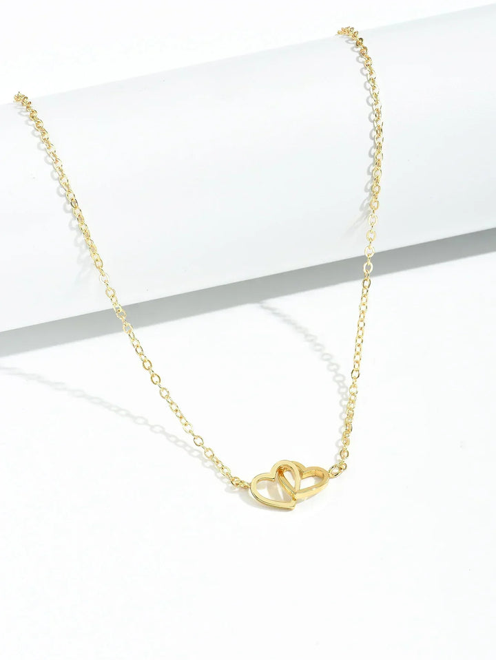 Elegant women's gold vermeil interlocking heart necklace worn, showcasing delicate sterling silver heart pendant jewelry.