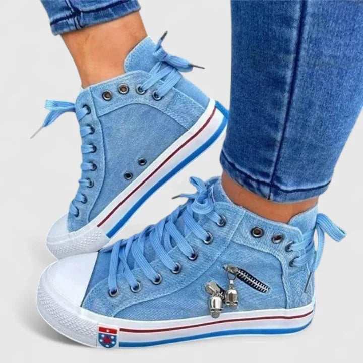 Close-up of women's denim high-top sneakers, showcasing intricate stud and zip details, a must-have for streetwear.