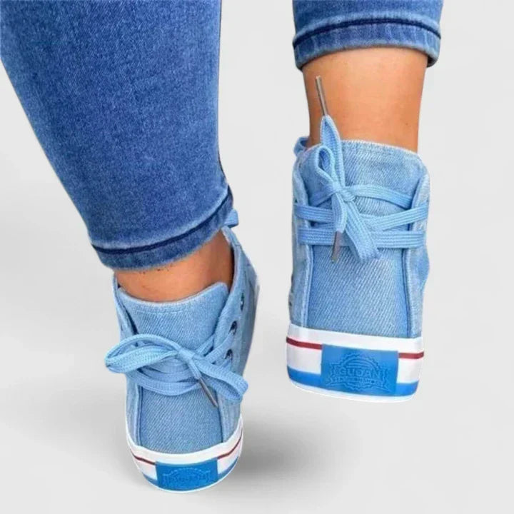 Stylish women's high-top sneakers in blue denim, adorned with chic zip and stud embellishments for a fashion statement.