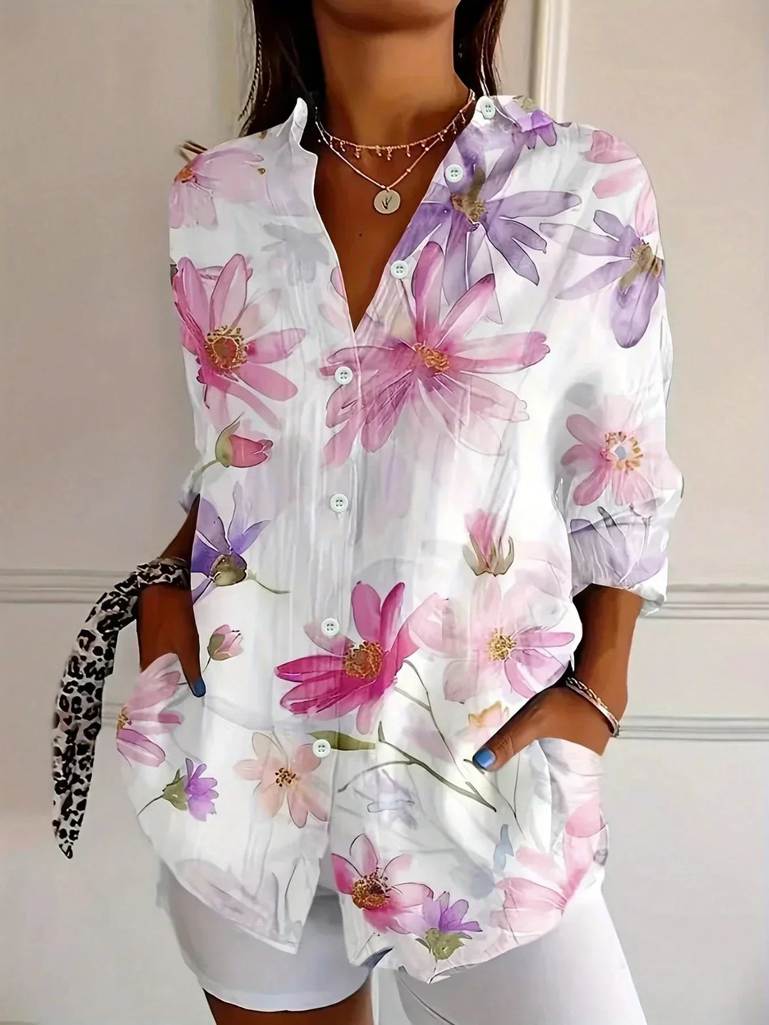 Relaxed fit women's blouse featuring a vibrant abstract pattern & full button front. Collared long sleeve top.