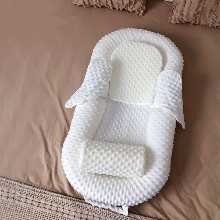 Baby sleeping soundly in an ergonomic infant nest (0-12 months) with breathable mesh & back support.