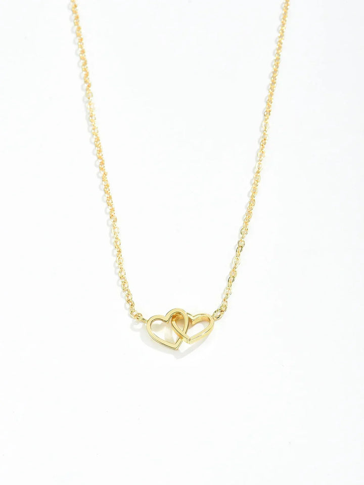 Close-up of delicate gold vermeil interlocking heart pendant, women's necklace on sterling silver chain.