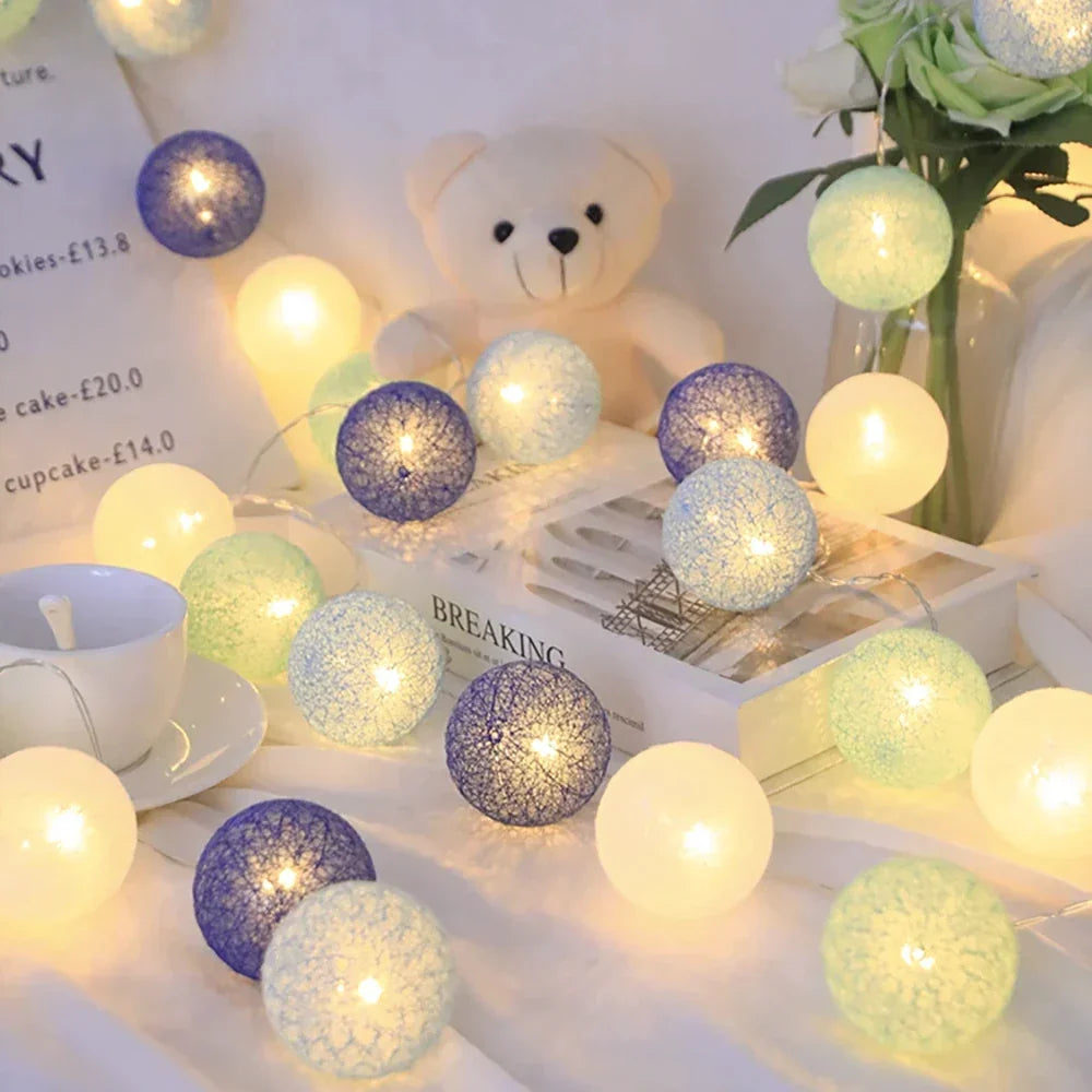 Close-up of a lit cotton ball on a string light garland, showcasing the warm LED glow.