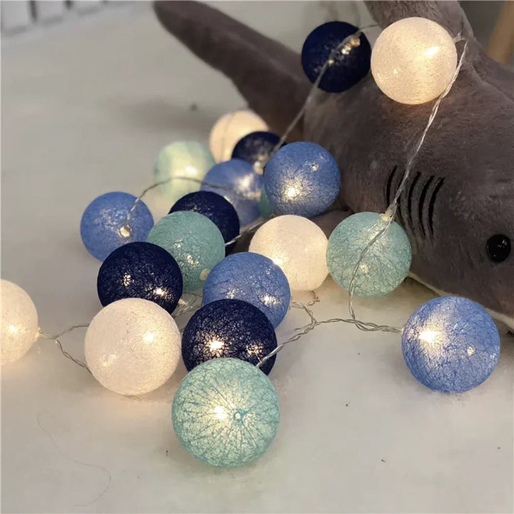 Aesthetic cotton ball LED garland glowing warmly against a wall, perfect for modern decor.