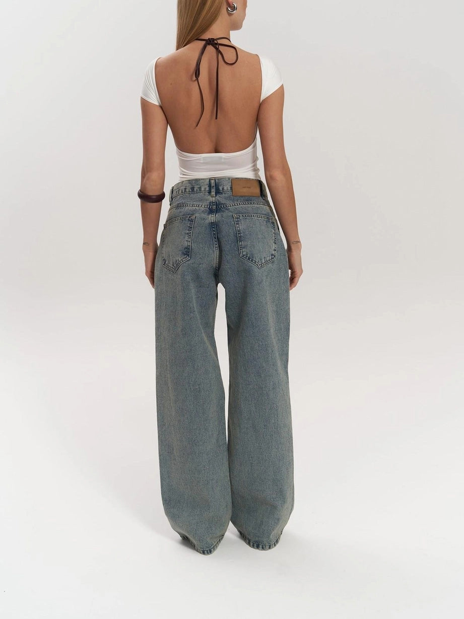 Close-up of the stylish mesh panel on women's high waist wide leg jeans. Unique, trendy denim fashion detail.