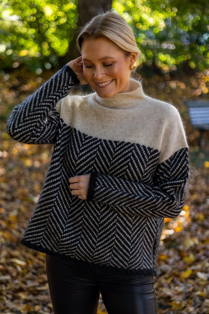 Elegant women's turtleneck sweater with chic chevron knit pattern. Long sleeve for cozy winter fashion.