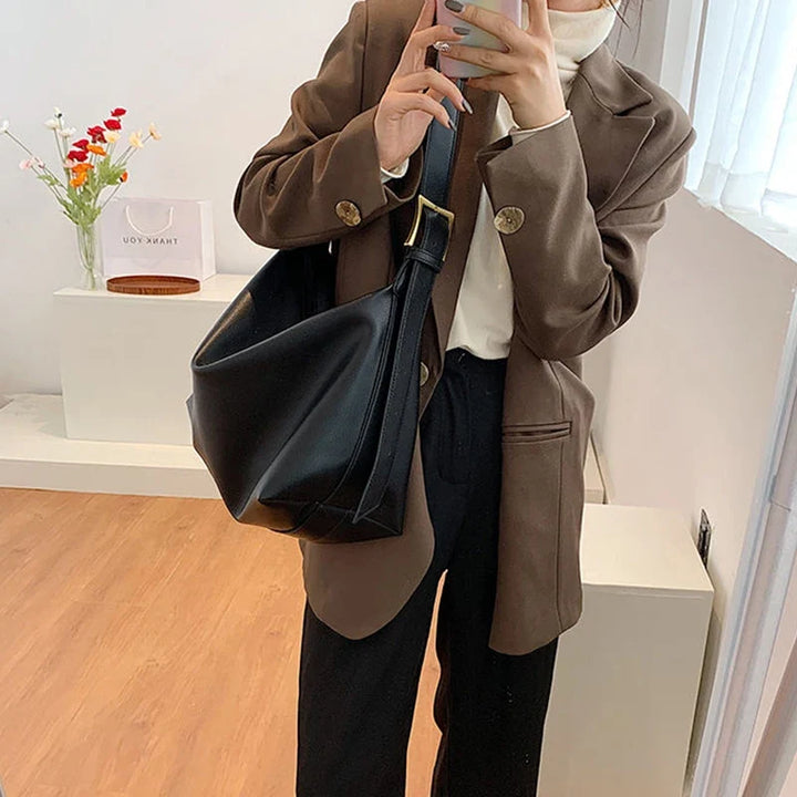 Side view of a spacious women's oversized faux leather tote, ideal as a versatile everyday shoulder bag.