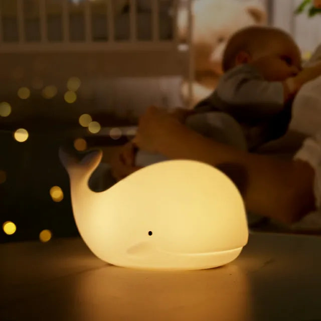 Whale-shaped soft silicone night light. Rechargeable LED lamp for children's bedtime, provides a gentle, colorful glow.