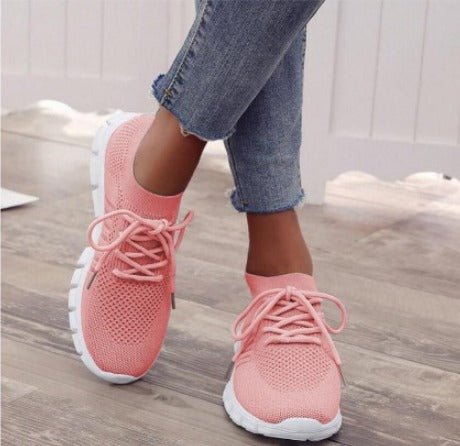 Close-up of women's modern lace-up athletic sneakers. Features flexible sole for ultimate comfort & active wear.
