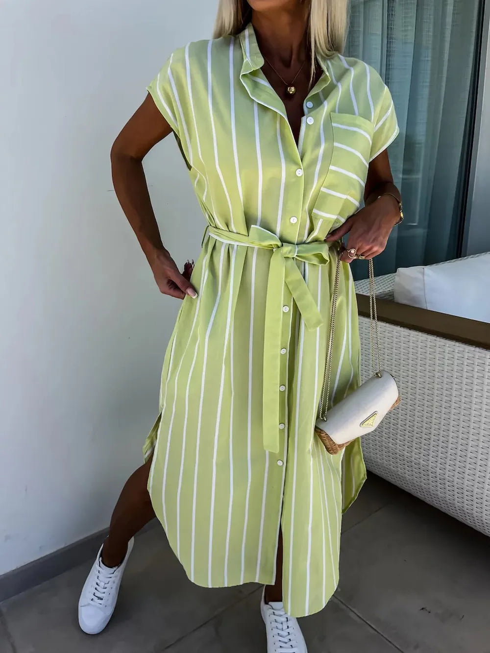 Neatly folded striped tie waist midi dress, showcasing its vibrant pattern and effortless chic design.