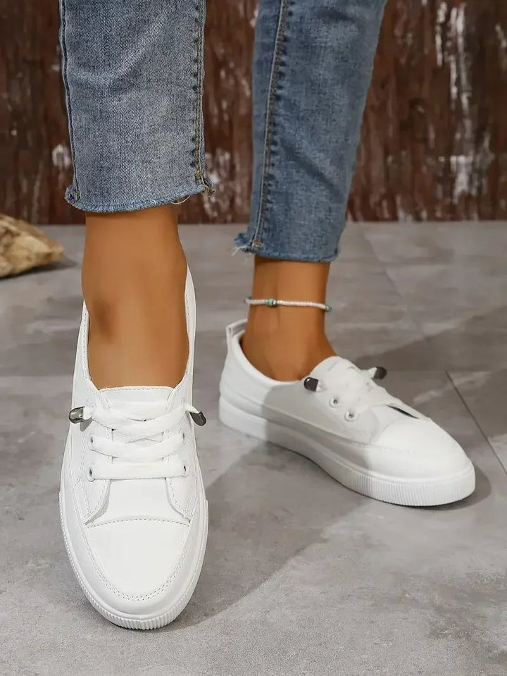Comfortable white women's casual sneakers, lace-up style with a round toe, perfect for daily wear.