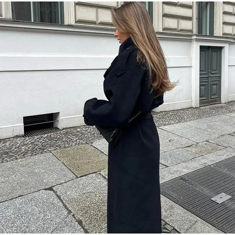 Classic women's double-breasted longline coat in black. Elegant and oversized outerwear for a timeless winter look.