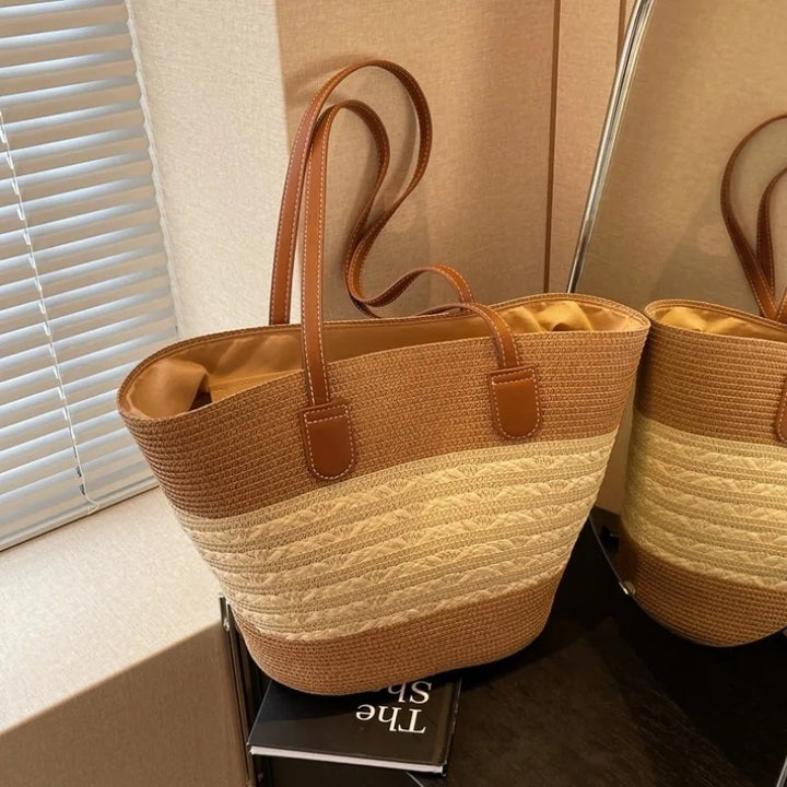 Close-up of a women's two-tone beach tote bag, highlighting its elegant design and shoulder straps.