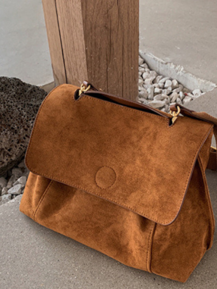 Comfortable women's brown crossbody bag featuring an adjustable shoulder strap & secure flap. Everyday versatility.