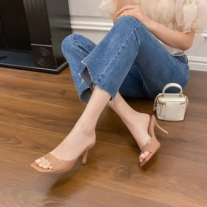 Modern women's open toe slip-on mules featuring an elegant square heel. Versatile chic footwear.
