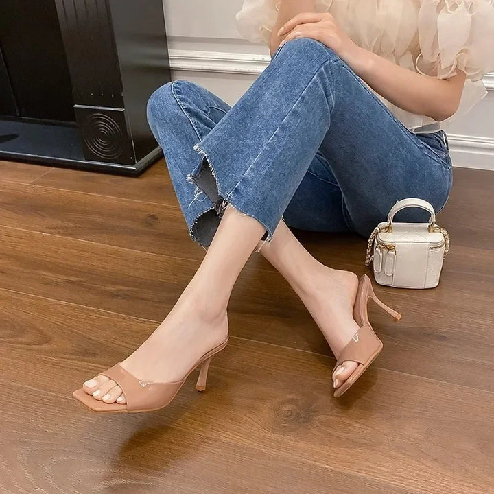 Modern women's open toe slip-on mules featuring an elegant square heel. Versatile chic footwear.