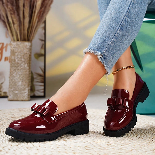 Modern women's chunky platform loafers, slip-on design, featuring a stylish bow. Glossy finish for a sleek look.
