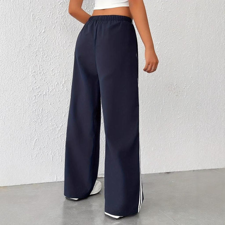 Elegant women's wide leg trousers, trackpant comfort, featuring a sharp side stripe. Athleisure chic.