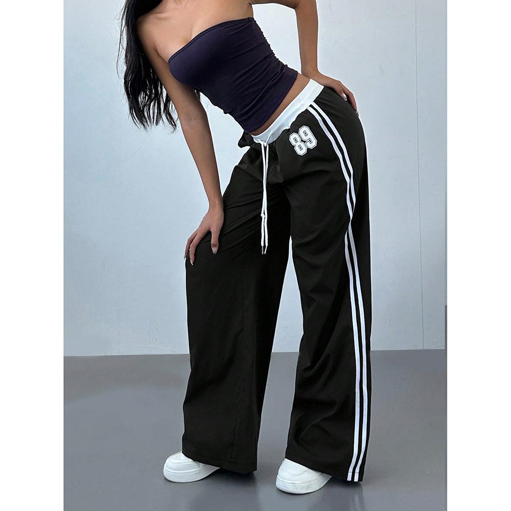 Chic women's striped wide leg trackpants, offering a comfortable, baggy fit and an adjustable drawstring for casual wear.