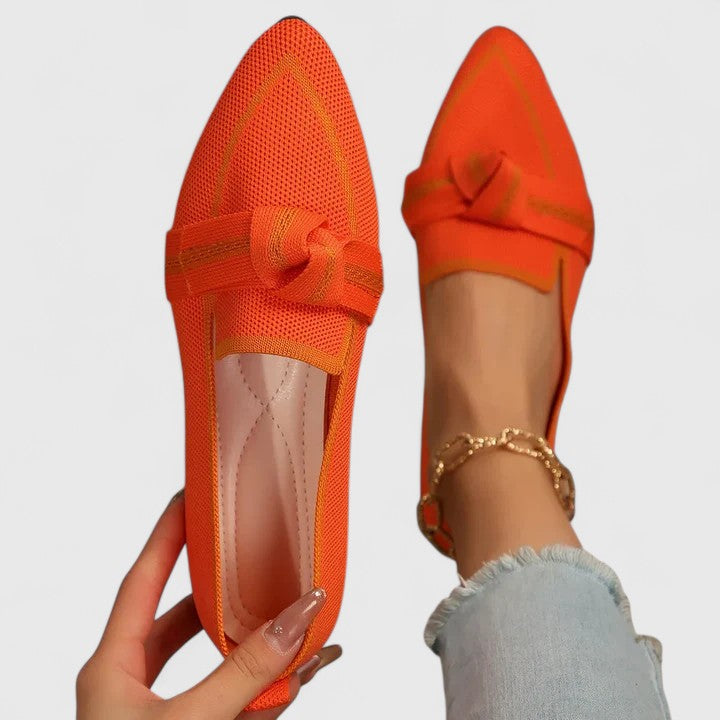 Close-up of elegant women's pointed-toe loafers, highlighting the decorative knot detail and slip-on style.