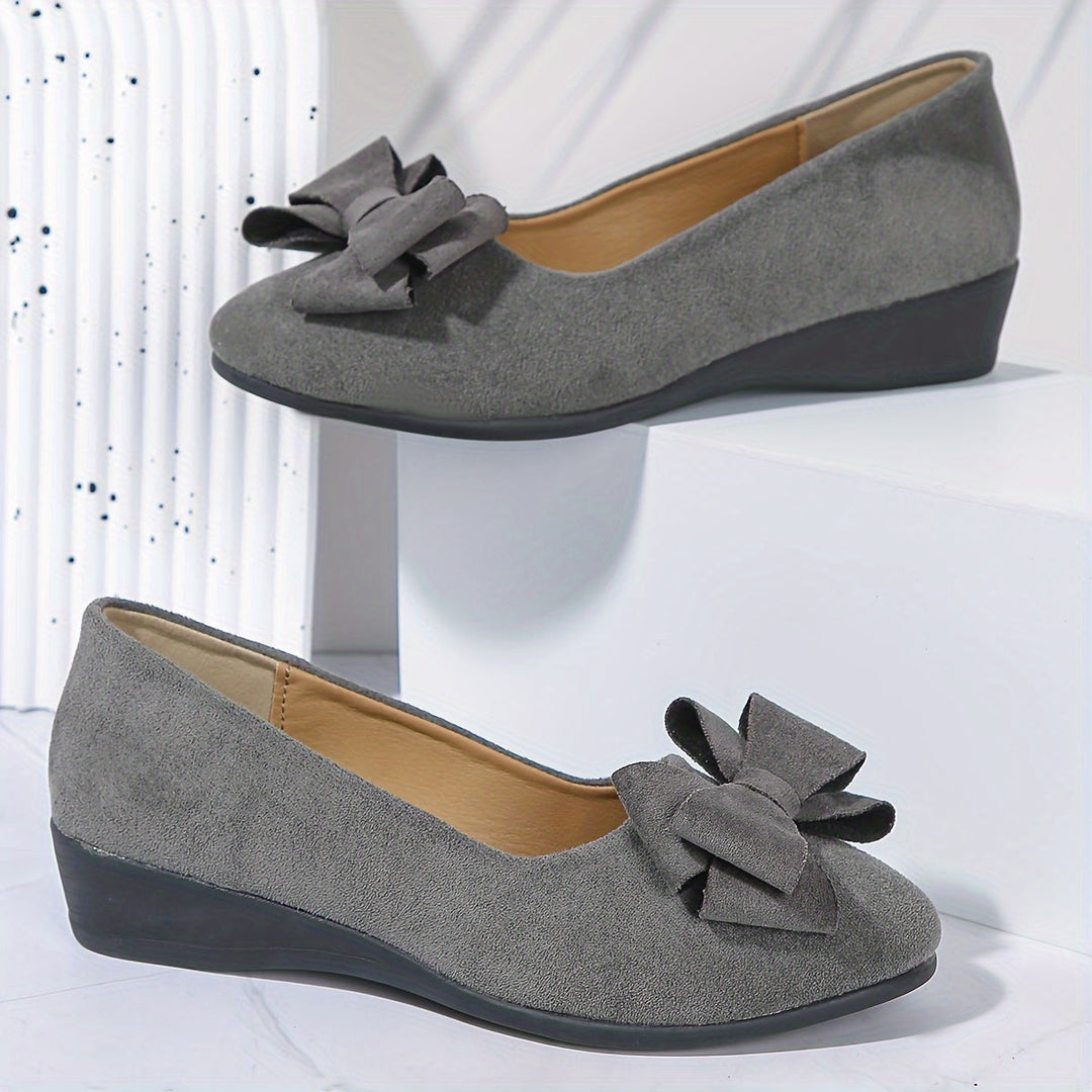 Soft pink women's wedge ballet flats, elegant slip-on shoes with a pretty bow detail for ladies.