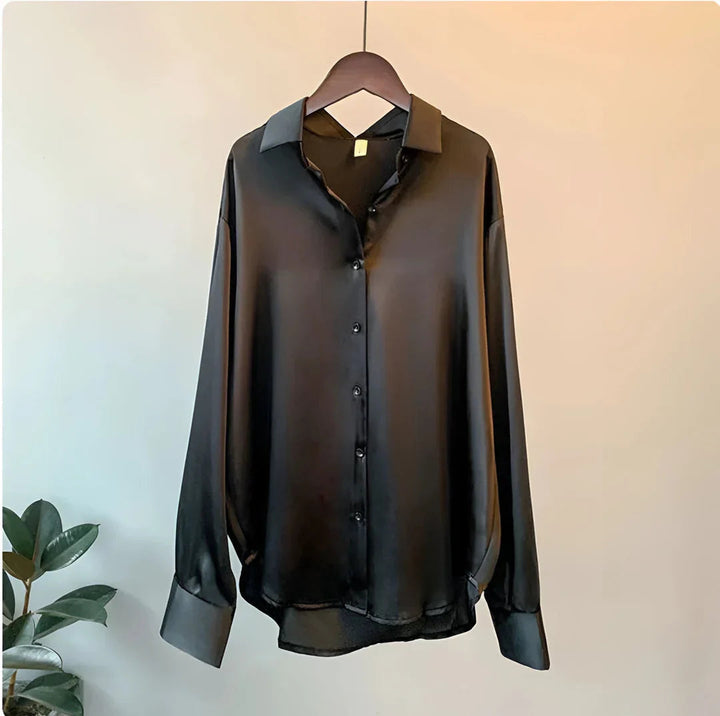 Flowy women's elegant button-up blouse with long sleeves. A chic and versatile fashion top for office wear.