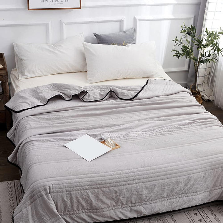 Light blue breathable cooling throw blanket draped elegantly over a modern sofa, enhancing home decor.