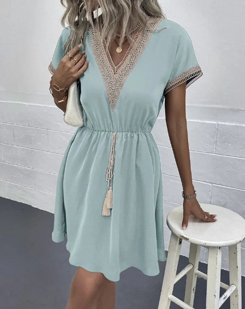 Boho-chic women's casual summer dress featuring intricate crochet trim, a flattering V-neck, and practical drawstring waist.