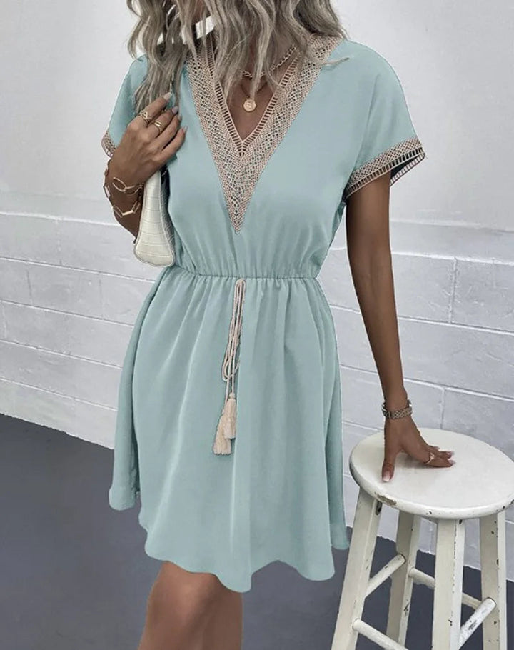 Boho-chic women's casual summer dress featuring intricate crochet trim, a flattering V-neck, and practical drawstring waist.