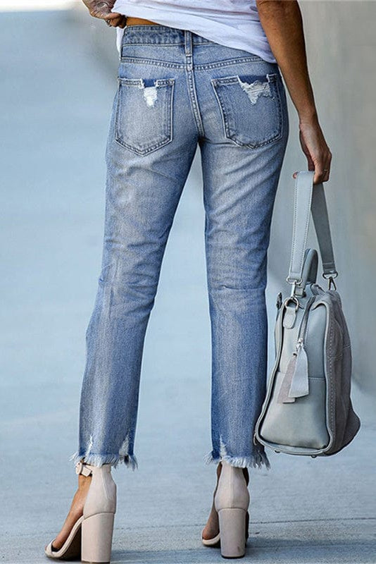 Trendy ripped women's straight leg jeans with a raw hem. Mid-rise, perfect for casual street style.