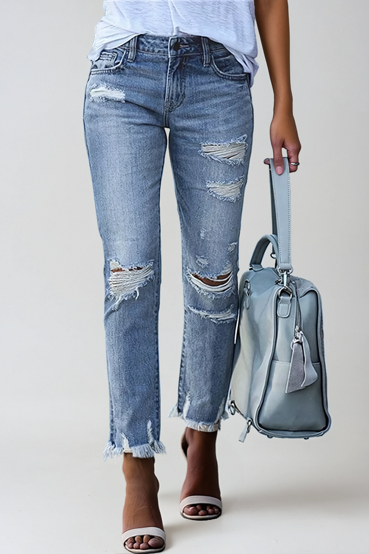 Women's distressed straight leg jeans with trendy raw hem. Perfect for casual street style.