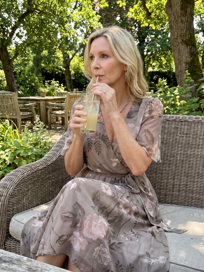 Back view: Women's floral print midi wrap dress, showcasing adjustable fit and flowing flutter sleeves.