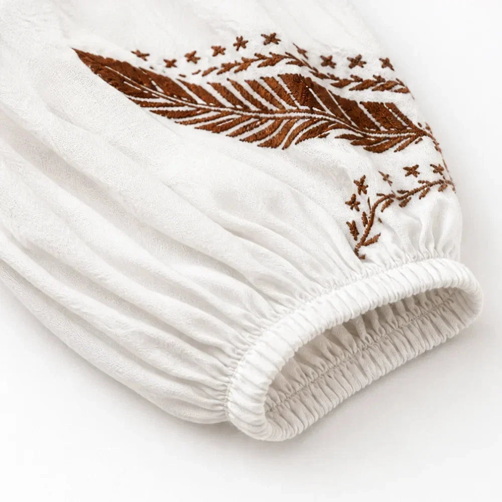 Flowy women's boho long-sleeve blouse with V-neck and detailed embroidery for a summer fashion statement.