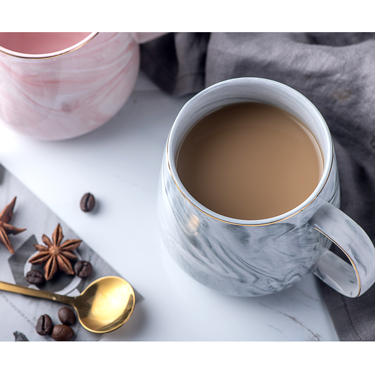 White marble pattern ceramic coffee mug featuring a stylish metallic gold rim. Elegant kitchenware.