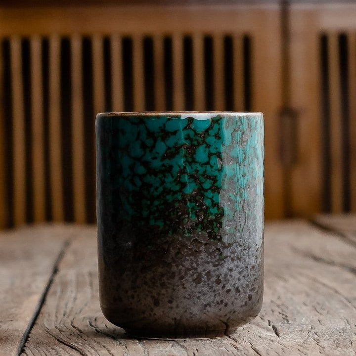 Artisan ceramic teacup, handleless Japanese design with unique crackle glaze, ideal for daily tea enjoyment.