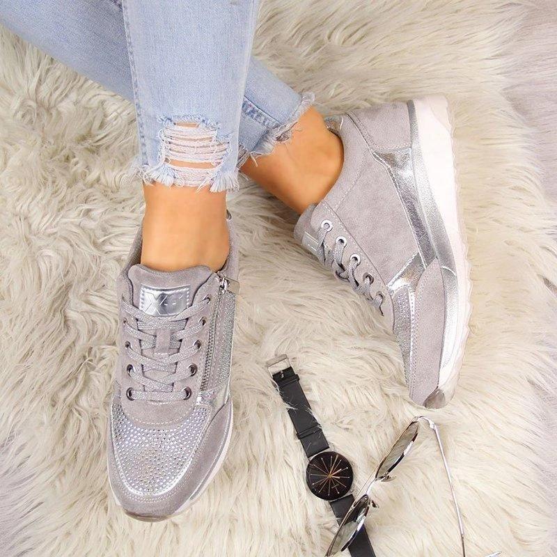 Close-up of women's rhinestone trainers: showing sparkle, zip, laces, & subtle heart detail on platform shoes.