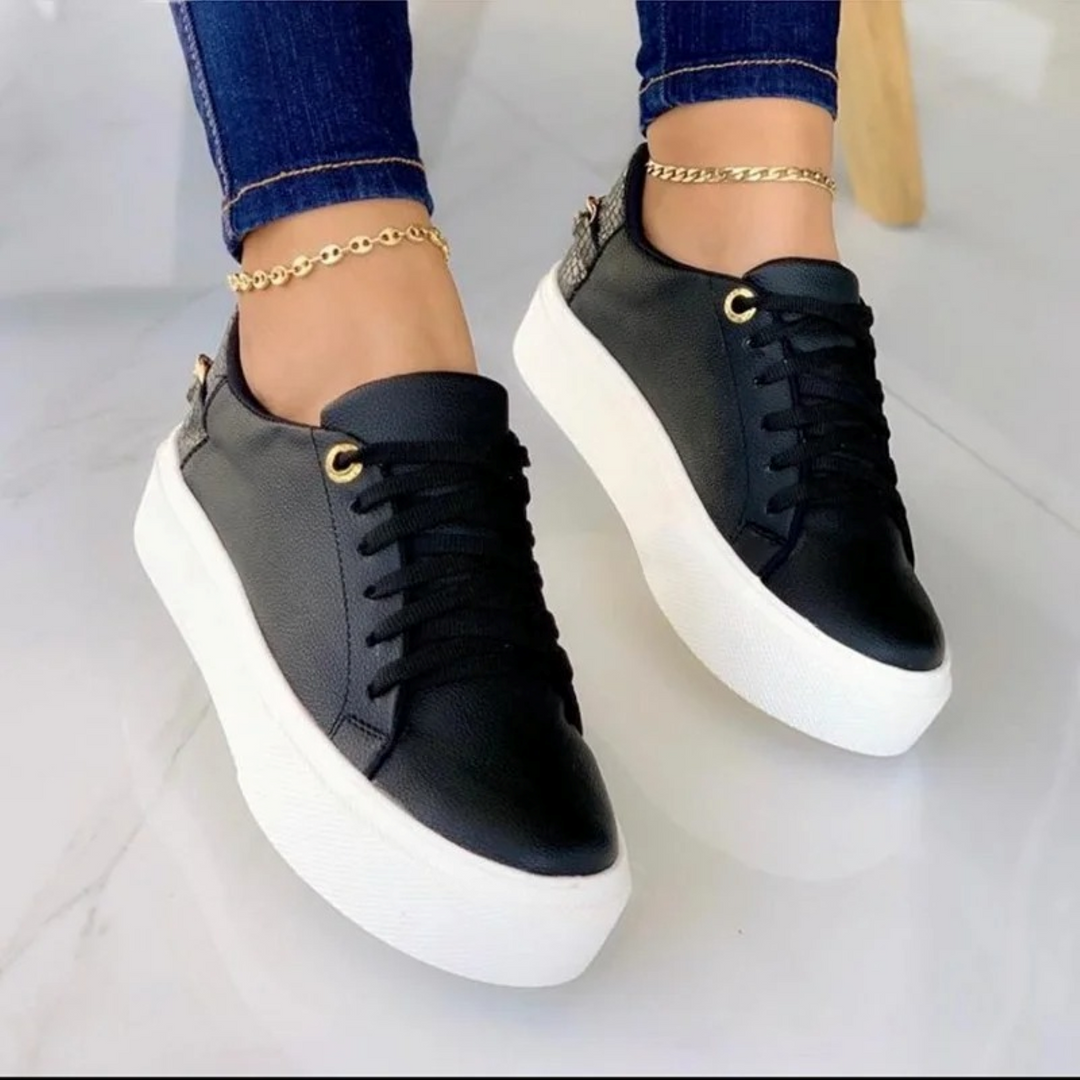 Comfortable white leather women's sneakers with a chic metallic chain, perfect for stylish casual footwear.