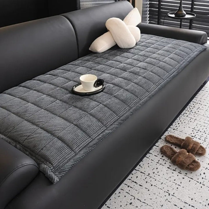 Stylish quilted slipcover for living room decor, providing a protective furniture shield.