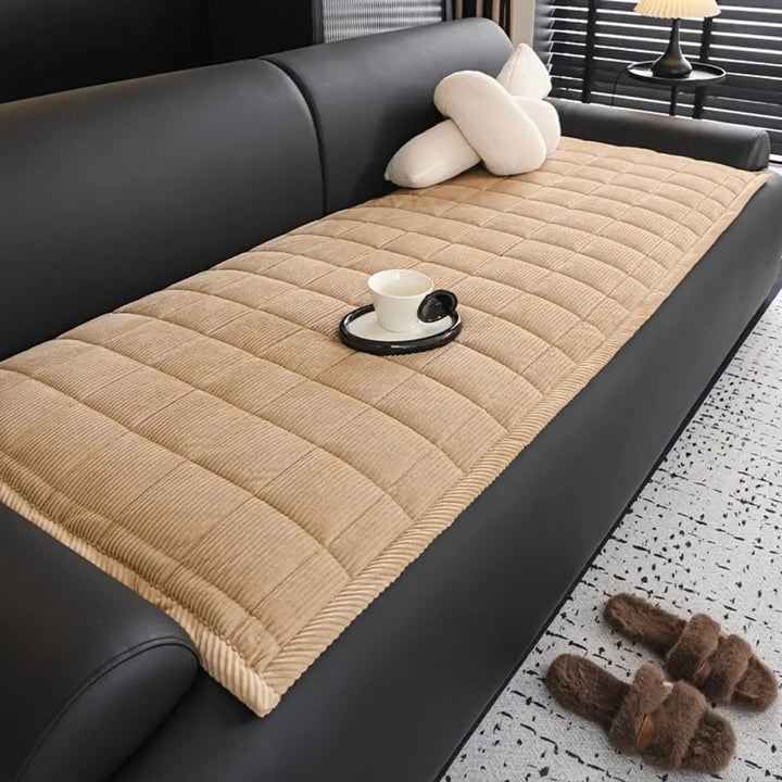 Quilted microfibre sofa protector in a modern home, offering pet-friendly furniture shield.