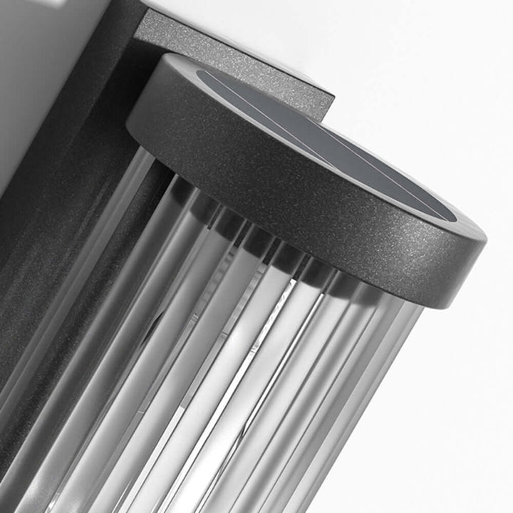Cylindrical solar-powered garden light. Weatherproof metal & glass lamp for bright, modern pathway illumination.