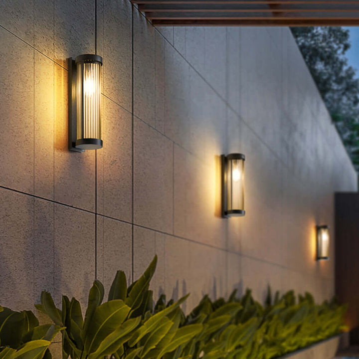 Modern cylindrical solar lamp, metal and glass, illuminating outdoor pathways. Weatherproof garden lighting.